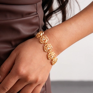 Detailed view of a gold rose necklace with crystals worn on a female neck for luxury style