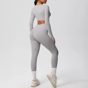 Detail of high-waist grey yoga leggings with side pocket and long sleeve crop top set