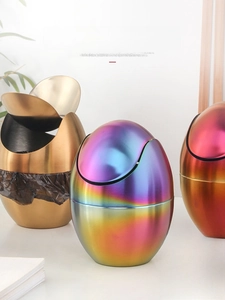 Detailed view of colorful egg-shaped stainless steel desktop trash cans for office use