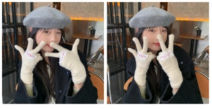 Detail of off-white knitted gloves with embroidered patch and grey wool beret