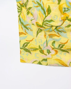 Detailed macro shot of linen-blend fabric featuring lemon yellow floral patterns and stitching