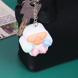 Detail of colorful macaron cat paw keychains made of soft silicone on a black bag