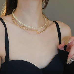 Detail of double-layer collar necklace with gold metal and marble resin ring on neck