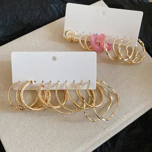 Gold-toned hoop earring set featuring resin details and textured patterns on a white card