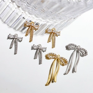Detailed view of 14k gold plated bow pendants with zircon pave and long tassels