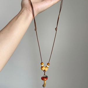 Handmade forest style mushroom pendant necklace with wooden beads and brown rope cord