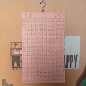 Pink felt jewelry organizer wall hanging with laser-cut slots for earrings and brooches