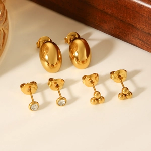 Detail of three-piece gold stud earring set featuring oval, zircon, and bead designs