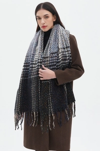 Detail shot of heavy wool blend gradient scarf with tassels worn over a brown coat