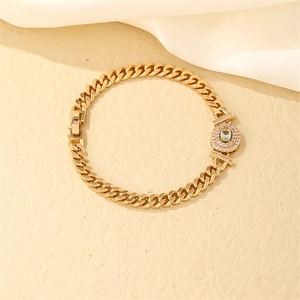Detailed close-up of golden Cuban chain bracelet featuring a light blue centerpiece stone