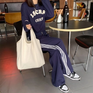 Navy leisure set paired with a large capacity cream canvas tote bag in a cafe setting