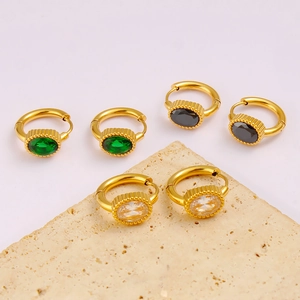 Gold oval zircon earrings in green, black, and clear crystals on a textured stone base