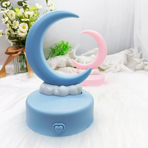 Detailed view of blue and pink crescent moon night lights on a soft plush cloud base