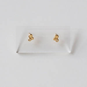 Detailed macro of gold honeycomb geometric stud earrings with tiny zirconia accents