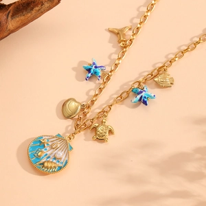 Gold ocean themed necklace featuring enamel shell, sea turtle, and starfish charms