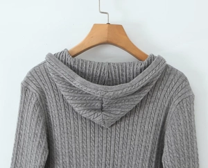 Detail view of the classic grey cable knit texture and hood on a casual cardigan