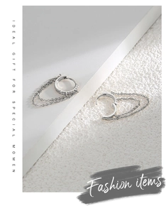 Close-up of silver hoop earrings with tassel chains and sparkling zircon stones