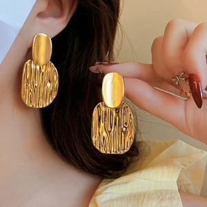 Fashionable oversized gold metal earrings with unique lava texture and vintage style