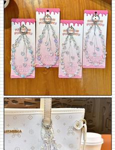 Detailed view of handmade heart beaded charms with pearls and crystals used on a white handbag