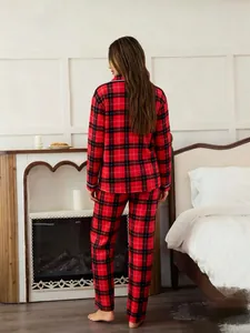 Back view of women's red plaid pajamas set in a cozy home setting with fireplace