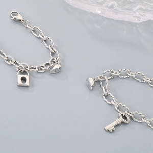 Detailed macro view of magnetic heart-shaped lock and key pendants on silver steel chains
