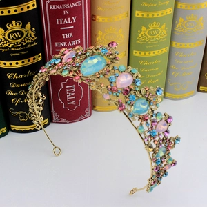 Detailed macro view of vintage gold bridal crown with colorful crystals on retro books