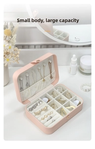 Pink jewelry box detail showing interior necklace hooks and ring storage slots