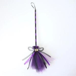 Detail of purple and black mesh witch broom with gold buckle for Halloween decor