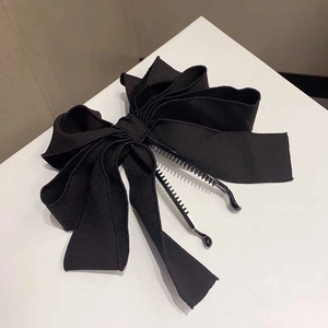 Detail of large black fabric bow hair clip with sturdy plastic banana claw clasp