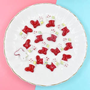 Detailed macro view of 15 red resin Christmas stocking miniatures on a white gold-rimmed plate