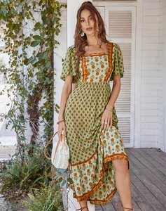Detail view of floral green dress with square neck and bohemian tiered ruffle hemline
