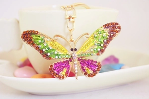 Close-up of colorful crystal butterfly keychain with vibrant rhinestones on a golden base