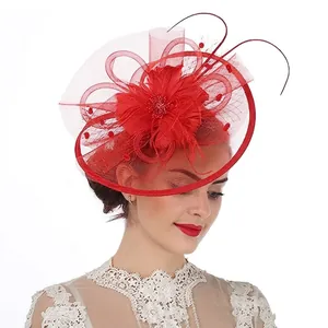 Detailed view of red mesh flower fascinator with feathers on a model for weddings