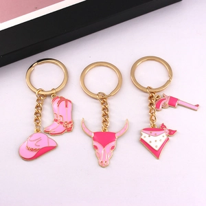 Pink western cowboy keychain set with hat, boots, and skull charms in gold alloy