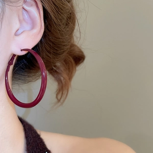 Side view detail of burgundy red enamel hoop earring with high-gloss finish for women