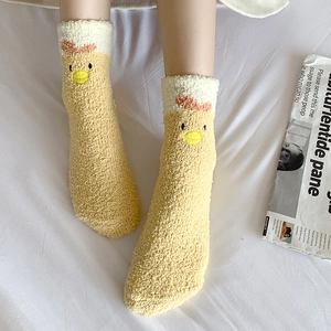 Close-up of thick yellow coral fleece socks with cute cartoon chick design for home