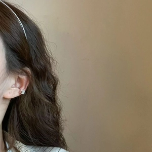 Detailed view of silver flower ear cuff with sparkling zircon accents on model