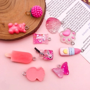 Collection of DIY resin pendants in rose red and pink featuring bears and candies