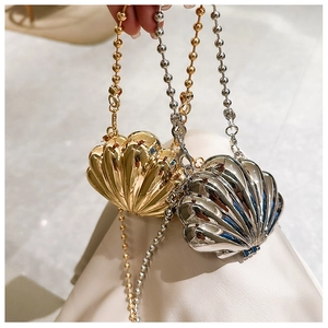Close-up of gold and silver shell-shaped metallic mini bags with round bead chain straps