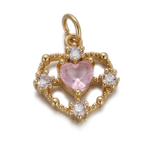 Macro view of gold heart pendant with pink gemstone and small crystal accents