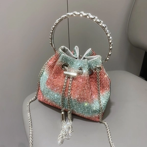Dettaglio borsa a secchiello con strass sfumati rosa e verdi e manici in cristallo