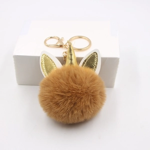 Porte-clés licorne en fausse fourrure marron avec corne dorée sur fond blanc neutre