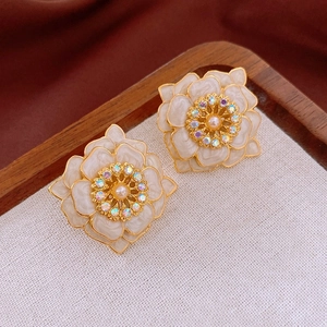 Macro shot of vintage cream enamel flower earrings with pearls and AB crystal centers