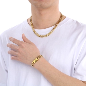 Dettaglio del set collana e bracciale in acciaio al titanio dorato con maglia NK su modello