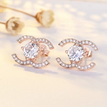 Macro shot of rose gold double C stud earrings with sparkling pave crystals