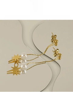 Detail of gold starburst earrings with white pearls and 18K vacuum plating finish