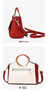 Detail view of red and white contrast handbag featuring round metal handle and back zip pocket