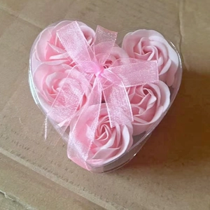 Pink heart-shaped gift box with soap roses and a matching ribbon bow detail