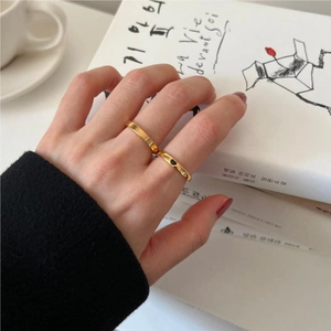 Minimalist gold heart ring set worn by model with coffee and book background