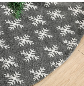 Close-up of grey fabric Christmas tree skirt featuring white snowflake jacquard texture